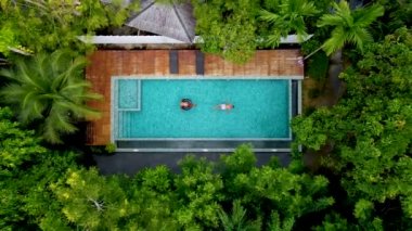 Krabi Tayland ormanlarında yüzme havuzunda bir çift erkek ve kadın, Tayland ormanlarında yüzme havuzunun üzerinde drone ile hava manzarası.. 