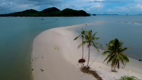 两名男子和女子在泰国Koh Yao Yai岛上的海滩上散步 海滩上长着白沙和棕榈树 — 图库视频影像