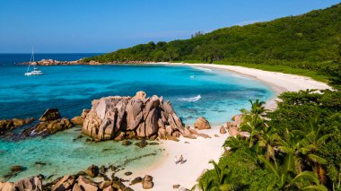 Anse Cocos beach, La Digue Island, Seyshelles, Drone aerial view of La Digue Seychelles bird eye view.of tropical Island, couple men and woman walking at the beach during sunset at a luxury vacation