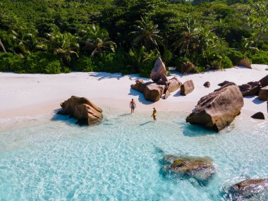 Anse Cocos plajı, La Digue Adası, Seyshelles, La Digue Seychelles 'in insansız hava görüntüsü. Tropik adanın kuş bakışı görüntüsü. Günbatımında plajda yürüyen birkaç erkek ve kadın.