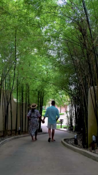 タイの竹のある熱帯の庭を歩いている男女が — ストック動画