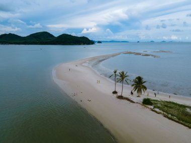 Ada Koh Yao Tayland 'da kumsalda yürüyen bir çift kadın ve erkek. Beyaz kum ve palmiye ağaçları olan bir kumsal..