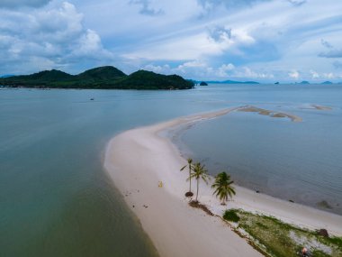 Ada Koh Yao Tayland 'da kumsalda yürüyen bir çift kadın ve erkek. Beyaz kum ve palmiye ağaçları olan bir kumsal..