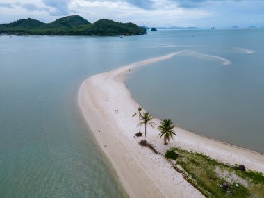 Ada Koh Yao Tayland 'da kumsalda yürüyen bir çift kadın ve erkek. Beyaz kum ve palmiye ağaçları olan bir kumsal..