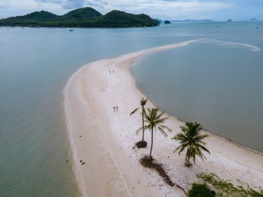 Ada Koh Yao Tayland 'da kumsalda yürüyen bir çift kadın ve erkek. Beyaz kum ve palmiye ağaçları olan bir kumsal..