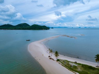 Ada Koh Yao Tayland 'da kumsalda yürüyen bir çift kadın ve erkek. Beyaz kum ve palmiye ağaçları olan bir kumsal..