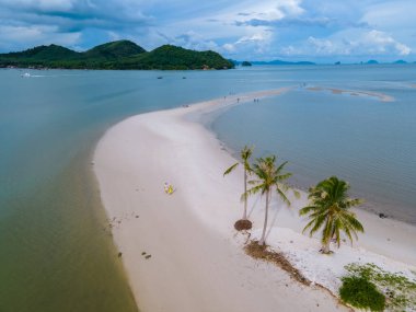Ada Koh Yao Tayland 'da kumsalda yürüyen bir çift kadın ve erkek. Beyaz kum ve palmiye ağaçları olan bir kumsal..