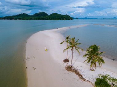 Ada Koh Yao Tayland 'da kumsalda yürüyen bir çift kadın ve erkek. Beyaz kum ve palmiye ağaçları olan bir kumsal..