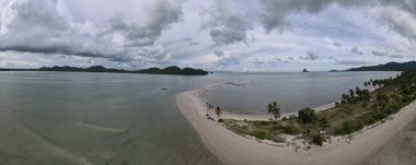 Ada Koh Yao Tayland 'da kumsalda yürüyen bir çift kadın ve erkek. Beyaz kum ve palmiye ağaçları olan bir kumsal..