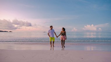 Praslin Seyşeller tropikal adası. Plajları ve palmiye ağaçları var. Orta yaşlı bir çift erkek ve kadın, Seyşeller 'de tatilde.