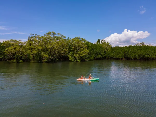 Tayland 'da Phuket Naka Adası' nda kayak yapan çift, tropik bir adada kayak yapan erkek ve kadın palmiye ağaçları ve mangrov ormanları olan. 
