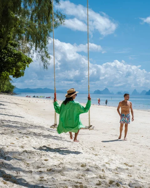 在泰国普吉岛附近的纳卡岛上 一对男女正在海滩上荡秋千 而男人则在热带海滩上散步 — 图库照片