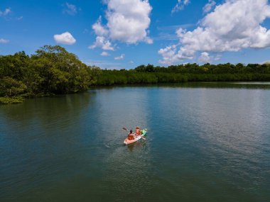 Tayland 'da Phuket Naka Adası' nda kayak yapan çift, tropik bir adada kayak yapan erkek ve kadın palmiye ağaçları ve mangrov ormanları olan. 
