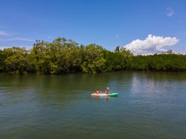 Tayland 'da Phuket Naka Adası' nda kayak yapan çift, tropik bir adada kayak yapan erkek ve kadın palmiye ağaçları ve mangrov ormanları olan. 