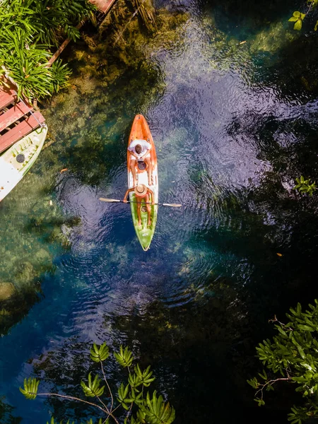 couple in a kayak in the jungle of Krabi Thailand, men and woman in kayak at a tropical jungle in Krabi mangrove forest.