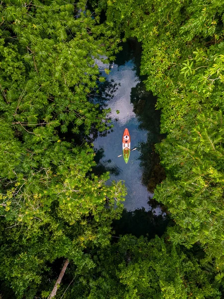 couple in a kayak in the jungle of Krabi Thailand, men and woman in kayak at a tropical jungle in Krabi mangrove forest.