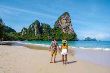 Railay Beach Krabi Tayland, Railay Krabi 'nin tropikal plajı, kumsalda bir çift kadın ve erkek, Tayland' da geleneksel uzun bir teknesi olan huzurlu Railay Kumsalı manzarası.. 