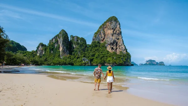Railay Beach Krabi Tayland, Railay Krabi 'nin tropikal plajı, kumsalda bir çift kadın ve erkek, Tayland' da geleneksel uzun bir teknesi olan huzurlu Railay Kumsalı manzarası.. 