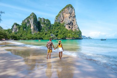 Railay Beach Krabi Tayland, Railay Krabi 'nin tropikal plajı, kumsalda bir çift kadın ve erkek, Tayland' da geleneksel uzun bir teknesi olan huzurlu Railay Kumsalı manzarası.. 