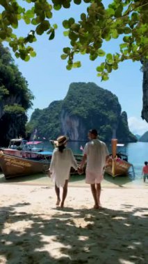 Koh Lao Lading, Koh Hong Krabi Tayland yakınlarında, uzun kuyruklu tekneli güzel bir sahil, birkaç Avrupalı erkek ve sahilde Asyalı bir kadın.. 