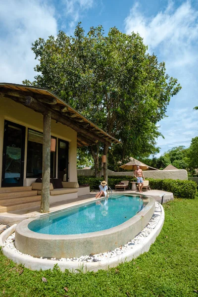 couple men and women on a luxury vacation at a pool villa. men and woman by swimming pool