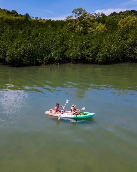 couple in a kayak in the ocean of Krabi Thailand, kayak at a tropical beach in Thailand. blue ocean and white beach of a tropical Island in Thailand