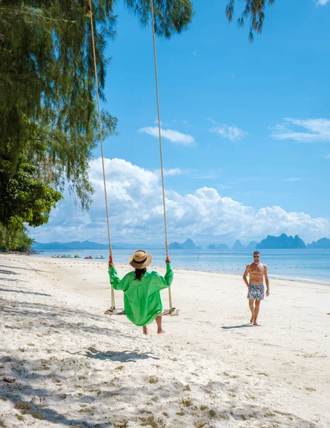 在泰国普吉附近的热带岛屿纳卡岛海滩上 一对男女 一个在海滩上荡秋千的女人 一个在海滩上荡秋千的男人 — 图库照片