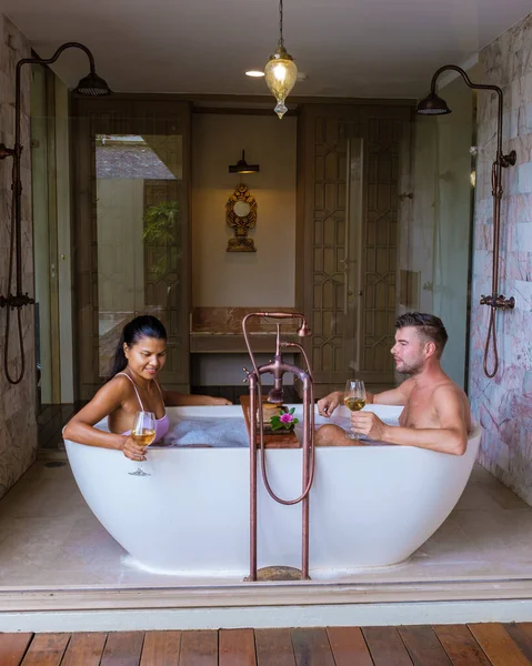 romantic bath tub with rose petals, luxury vacation in jacuzzi, couple men and woman in bath tub of a luxury resort during vacation