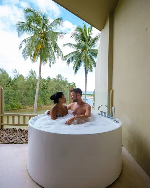 romantic bath tub with rose petals, luxury vacation in jacuzzi, couple men and woman in bath tub of a luxury resort during vacation