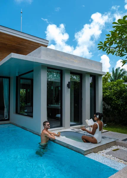 couple men and women on a luxury vacation at a pool villa. men and woman by swimming pool