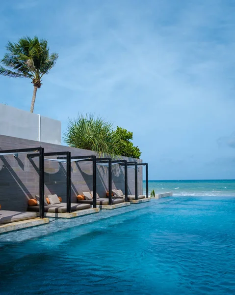 Modern Infinity pool at the beach. luxury infinity pool with beach beds