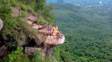 Ejderha Tepesi dağı Krabi Tayland, genç bir gezgin uçurumun üzerindeki kayanın üzerinde oturuyor, güzel bir manzarası var. Tayland, Krabi 'deki Khao Ngon Nak Doğa Yolu' nda Ejder Tepesi veya Khuan Sai.