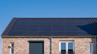 Güneşli bir gökyüzüne bağlı güneş panelleri olan yeni evler inşa edin. Siyah güneş panelleri olan yeni binaları kapatın. Zonnepanelen, Zonne enerjisi, Çevirisi: Güneş paneli, Güneş Enerjisi. 