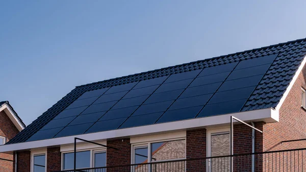 Güneşli bir gökyüzüne bağlı güneş panelleri olan yeni evler inşa edin. Siyah güneş panelleri olan yeni binaları kapatın. Zonnepanelen, Zonne enerjisi, Çevirisi: Güneş paneli, Güneş Enerjisi. 