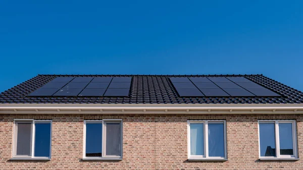 Nybyggda Hus Med Solpaneler Fästa Taket Mot Solig Himmel Närbild — Stockfoto