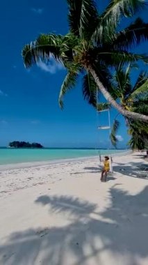 Cote DOr Beach, Praslin Seychelles, tropical beach during a luxury vacation in Seychelles. Asian woman on a swing at the beach