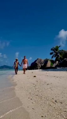 Anse Source dArgent, La Digue Seychelles, a young couple of men and women on a tropical beach during a luxury vacation in Seychelles. Tropical beach Anse Source dArgent, La Digue Seychelles