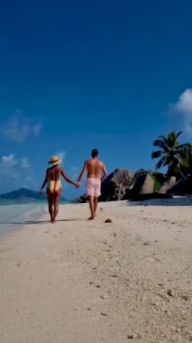 Anse Source dArgent, La Digue Seychelles, a young couple of men and women on a tropical beach during a luxury vacation in Seychelles. Tropical beach Anse Source dArgent, La Digue Seychelles