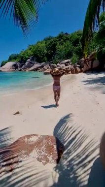 Anse Source dArgent, La Digue Seychelles, a young woman on a tropical beach during a luxury vacation in Seychelles. Tropical beach Anse Source dArgent, La Digue Seychelles