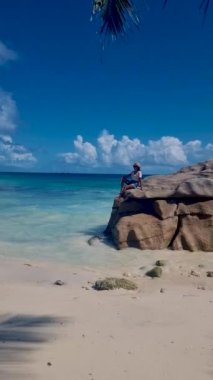 Anse Source dArgent, La Digue Seychelles, Seyşeller 'de lüks bir tatil sırasında tropik bir plajda yaşayan genç bir kadın. Tropik sahil Anse Kaynak dArgent, La Digue Seyşeller