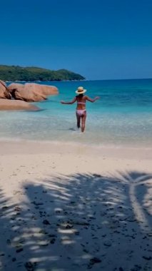 Anse Source dArgent, La Digue Seychelles, Seyşeller 'de lüks bir tatil sırasında tropik bir plajda yaşayan genç bir kadın. Tropik sahil Anse Kaynak dArgent, La Digue Seyşeller