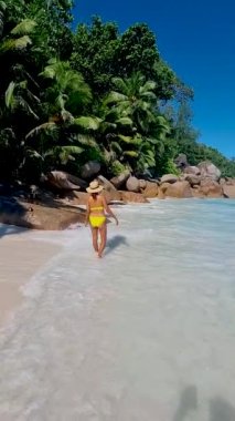 Anse Source dArgent, La Digue Seychelles, Seyşeller 'de lüks bir tatil sırasında tropik bir plajda yaşayan genç bir kadın. Tropik sahil Anse Kaynak dArgent, La Digue Seyşeller