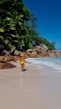 Anse Source dArgent, La Digue Seychelles, Seyşeller 'de lüks bir tatil sırasında tropik bir plajda yaşayan genç bir kadın. Tropik sahil Anse Kaynak dArgent, La Digue Seyşeller