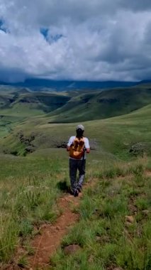 Drakensberg Dev Şatosu Güney Afrika, Drakensberg Dağı, Orta Drakensberg Kwazulu Natal, Güney Afrika 'da yeşil dağlar, dağlarda yürüyüş yapan genç Asyalı kadın.