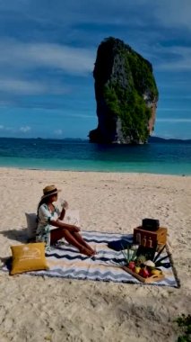 Koh Poda Krabi Tayland 'da, Asyalı bir kadın ve Avrupalı bir erkek Koh Poda Adası Yengeç Tayland' da piknik yapıyorlar.. 