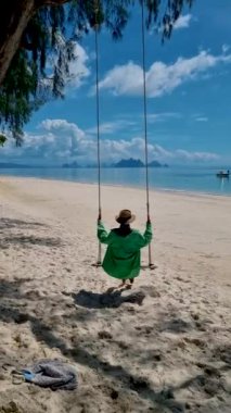 Plajda salıncakta sallanan kadın, Phuket Tayland yakınlarındaki tropikal ada Naka Adası 'nda. Naka Adası Phuket Tayland