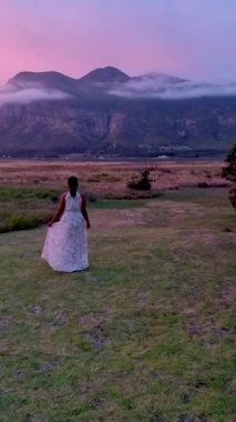 Hermanus yakınlarındaki dağlar ve çayırlar Batı Cape Güney Afrika Balina Sahili 'nde. Güney Afrika' da tatil yaparken orta yaşlı bir kadın kulübelerinin önünde.