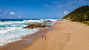 St. Lucia Güney Afrika, erkek ve kadın Zululand 'daki Isimangaliso Wetland Parkı' ndaki Cape Vidal yakınlarındaki Mission Rocks plajında yürüyor. Güney Afrika St Lucia