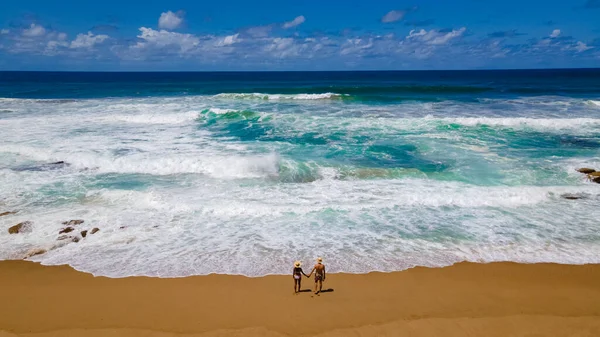 St Lucia South Africa, men and woman walking at the beach Mission Rocks beach near Cape Vidal in Isimangaliso Wetland Park in Zululand. South Africa St Lucia