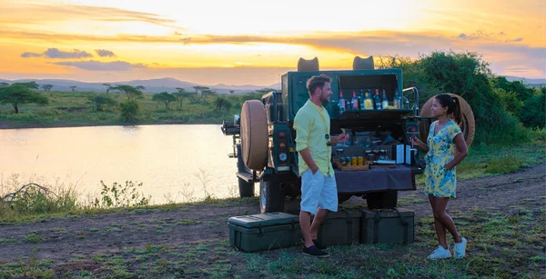 couple men and Asian woman on safari in South Africa, South Africa Kwazulu Natal, luxury safari car during a game drive, couple men and woman on safari in South Africa.